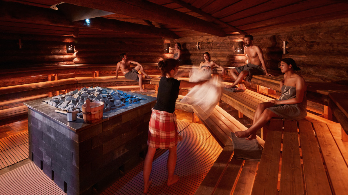 Een groep gasten ontspannen van een opgieting in de kelosauna van Thermen Holiday